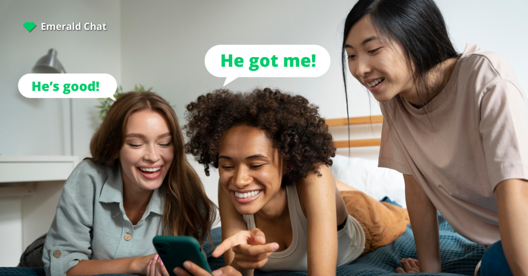 Three friends lie on a bed laughing while looking at a phone, with chat bubbles that say “He’s good!” and “He got me!” and an Emerald Chat logo in the corner.