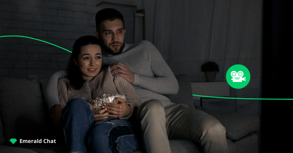  A man and woman sitting on a couch holding a chocolate bar