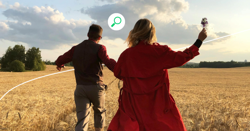 A man and a woman holding hands in a field