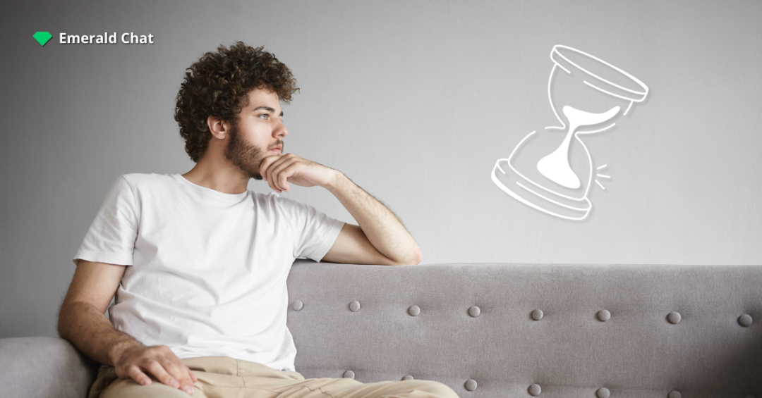 A man sitting on a couch staring off to the side with an hourglass icon beside him, symbolizing the slow or limited chances to meet new people.