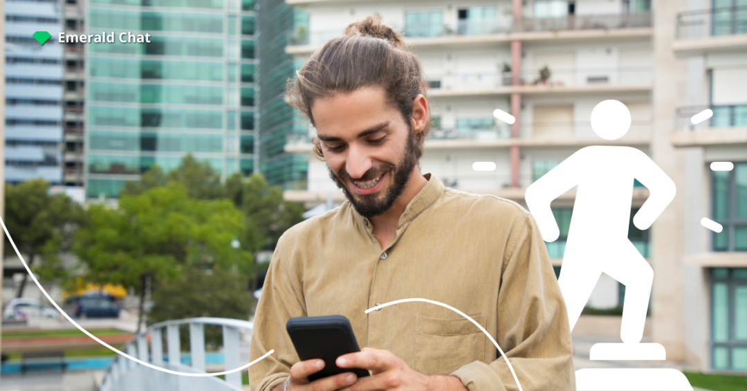 Man looking at his phone with a soft smile, reflecting the subtle feelings of liking someone from afar after an online conversation