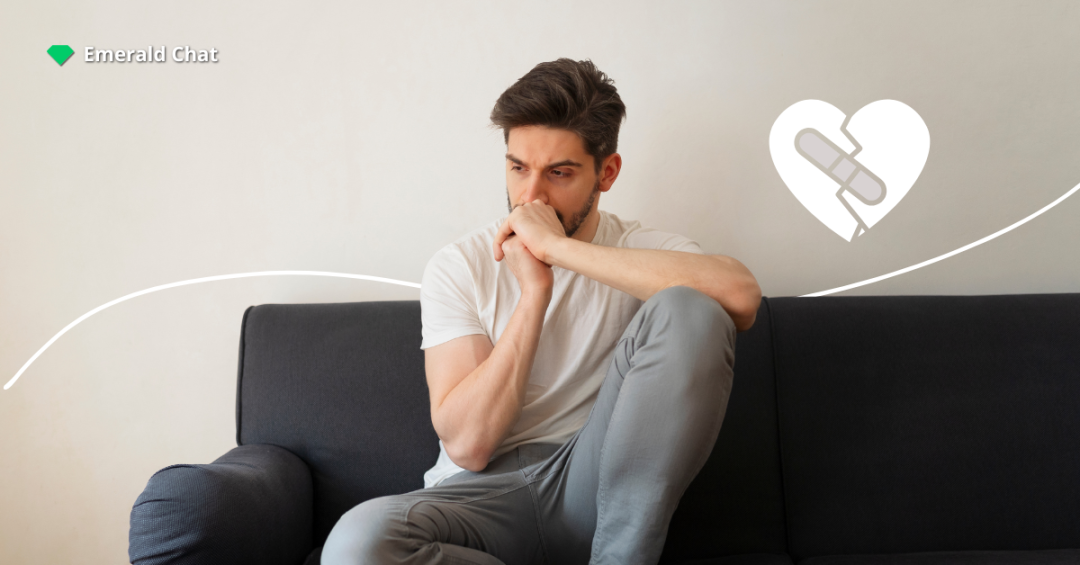 A man sitting alone on a couch, looking worried with his hands near his mouth, next to a broken heart icon patched together.