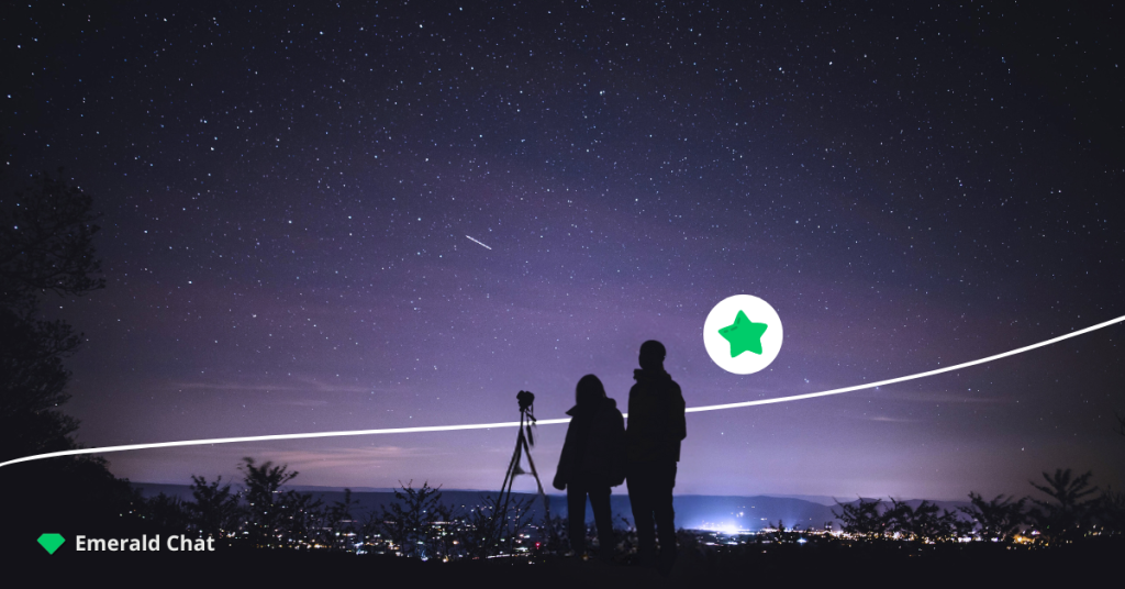 A couple of people looking at the stars in the night sky.