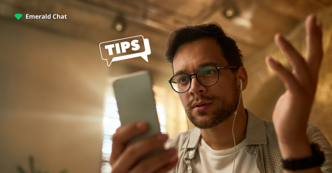 A man wearing glasses looks confused while staring at his phone, with a speech bubble that says “TIPS” and the Emerald Chat logo in the corner.