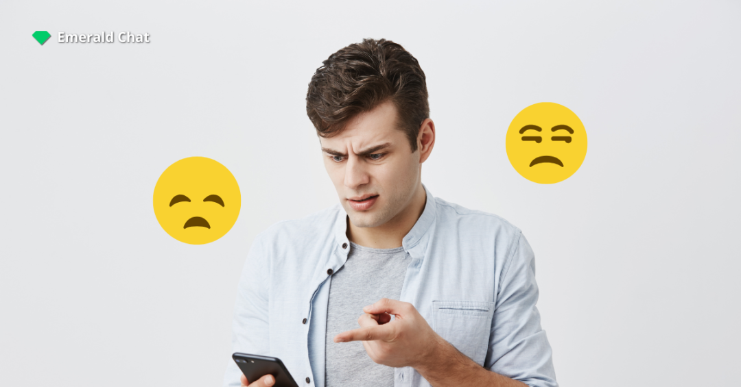 A frustrated man points at his phone with confused expression while two unhappy emojis float beside him and the Emerald Chat logo appears in the corner.